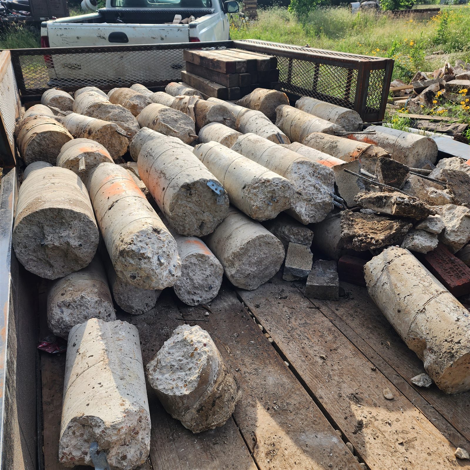 A trailer loaded with old concrete piers removed from a home