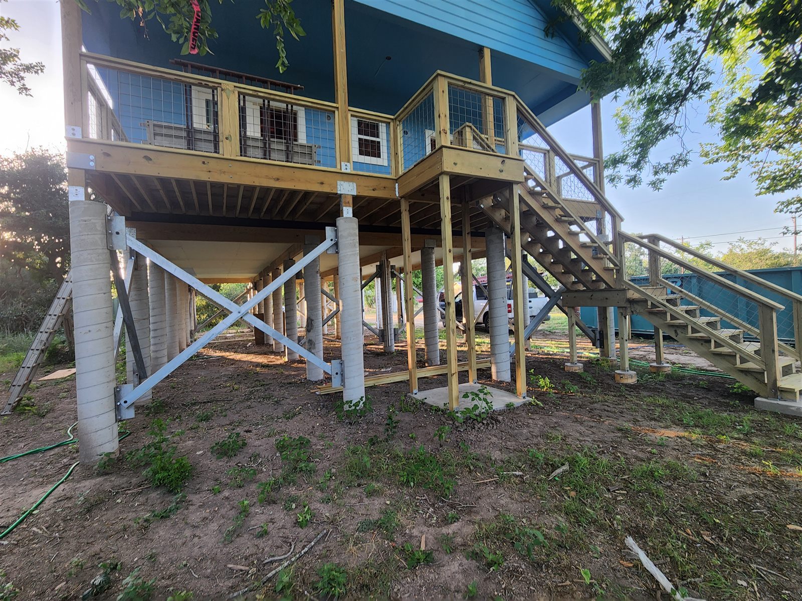 A home set on tall concrete piers, lifted well above grade